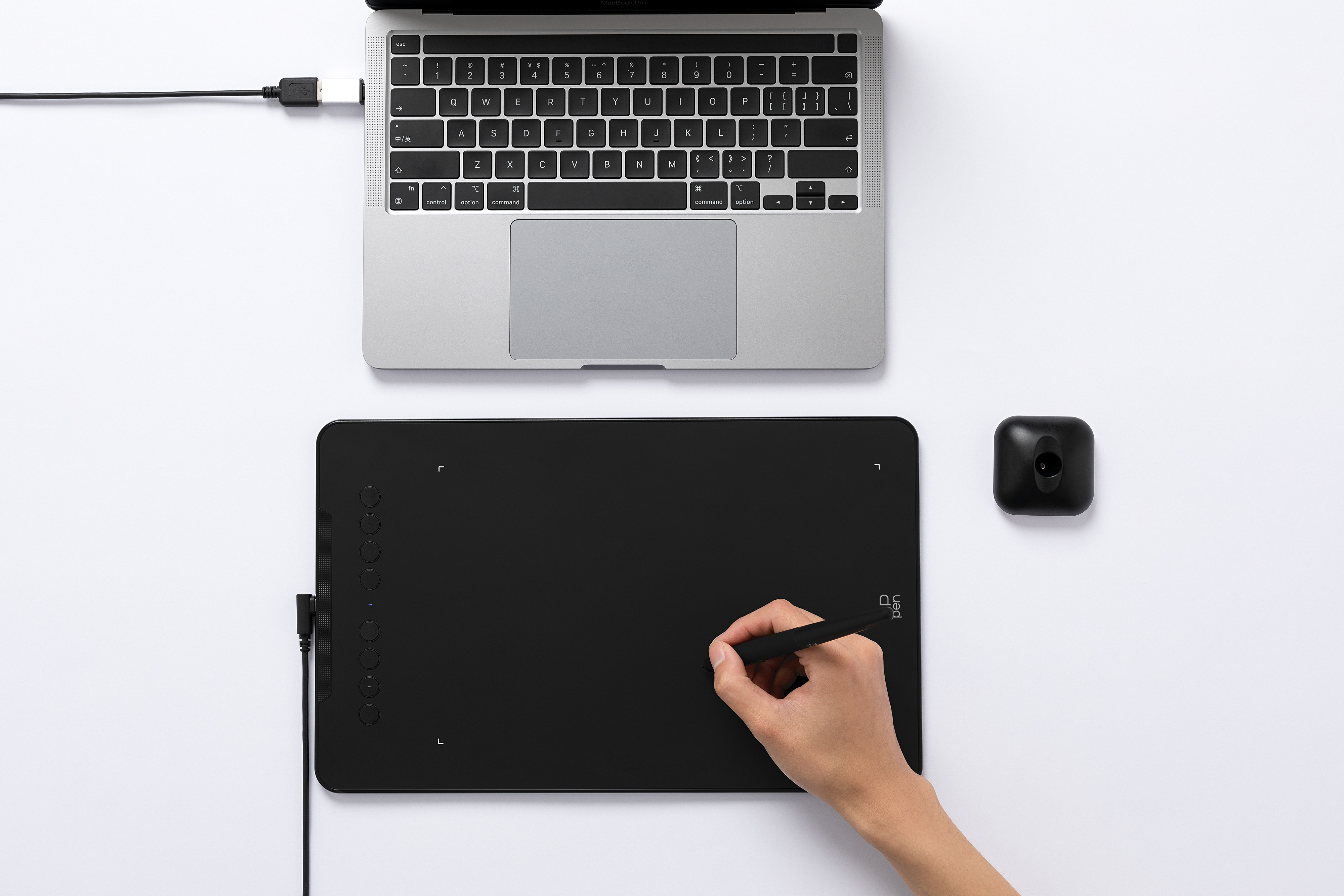 Imagen cenital de la tableta con una mano dibujando con el l&aacute;piz sobre ella y conectada a un notebook