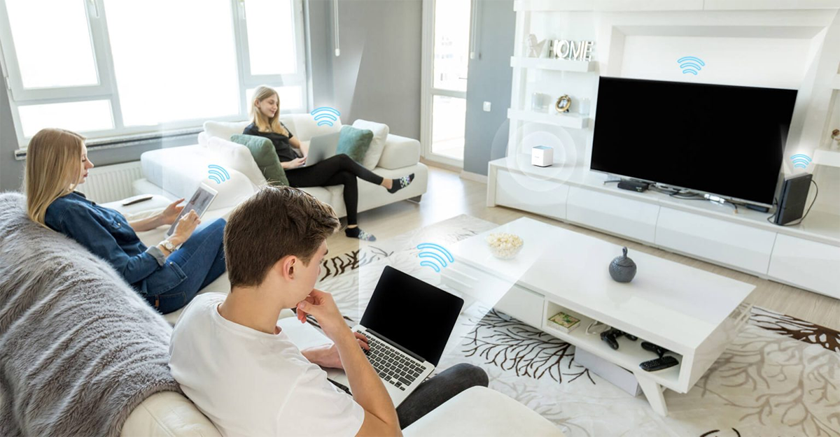 Familia reunida en sala de hogar con distintos dispositivos conectados a la red gracias al Router Mesh Dlink Eagle Pro M15