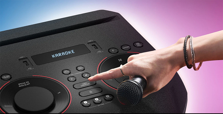 Detalle de la parte superior del equipo donde se aprecian las ranuras para colocar dispositivos m&oacute;viles, dos puertos USB, entrada de micr&oacute;fono y controles dedicados para karaoke y efectos de voz.