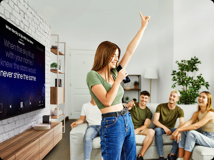Grupo de amigos cantando karaoke con funcionalidad incorporada en Smart TV Samsung Crystal UHD